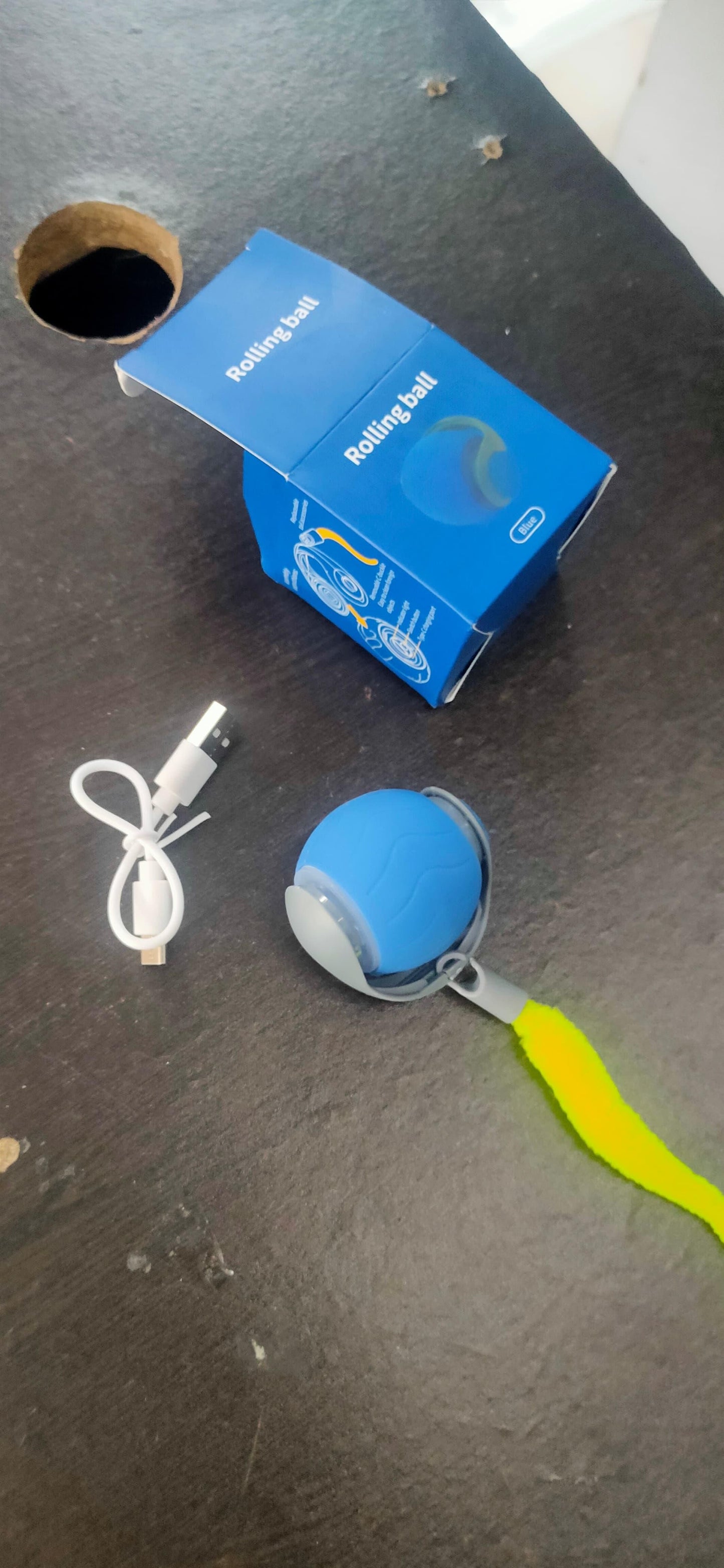 Blue device with USB cable and packaging on a dark surface