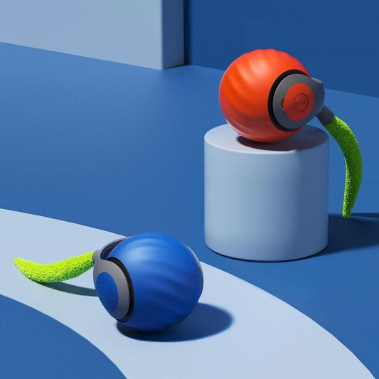 Red and Blue smart rolling pet toy ball with green feather on a blue background.